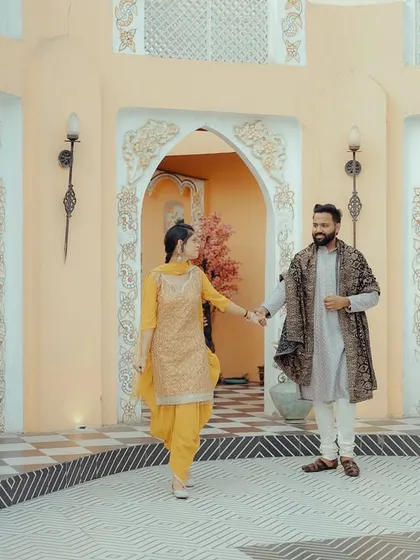 A walking shot through a studio set with beautiful archways. This captures a sense of movement and storytelling, as if the couple is exploring a new place together.