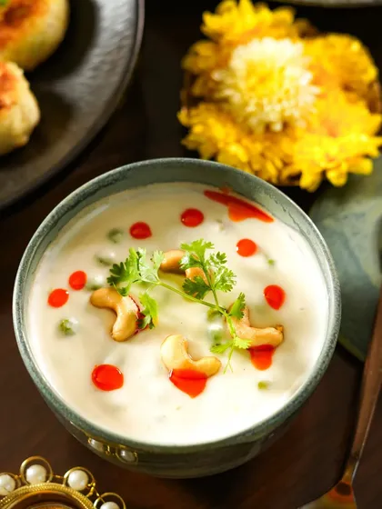 A creamy bowl of cashew and vegetable korma, garnished with fresh cilantro. The warm, festive lighting and traditional bowl make this dish look rich and inviting for a Diwali celebration.