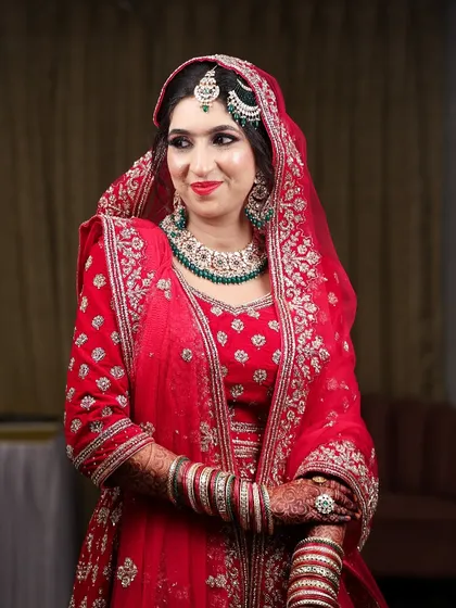 My beautiful bride Sidra, glowing for her Nikah. This look features a classic red lip and soft eyes, paired with green jewelry for a timeless combination.