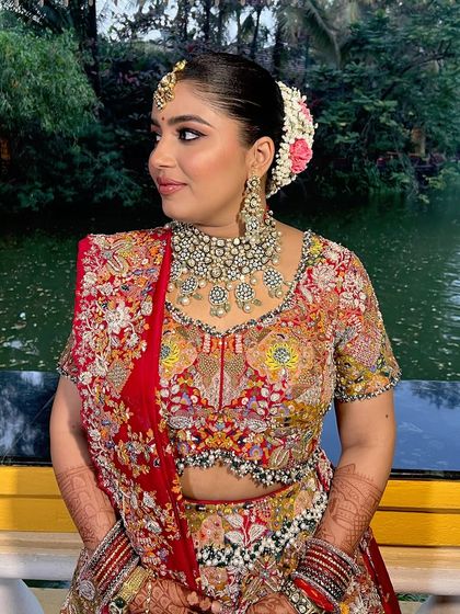 A side view highlighting the elegant floral bun and the beautiful profile of the bride.