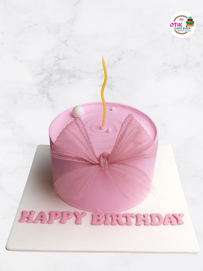 Simplicity at its finest. This minimalist pink cake features a subtle ripple effect on top and a delicate tulle bow, proving that sometimes less is more when it comes to elegant design.