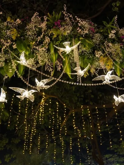 A full view of the hanging crystal birds and fairy light curtain, an element that adds depth and sparkle to our floral archways and entry passages.