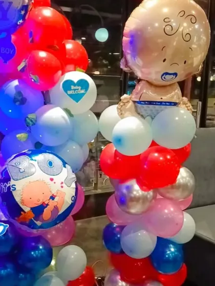 A close-up of the balloon columns from the boy's baby shower. I use a mix of different sized balloons and themed foils like the baby boy and "It's a Boy" designs to add more detail.