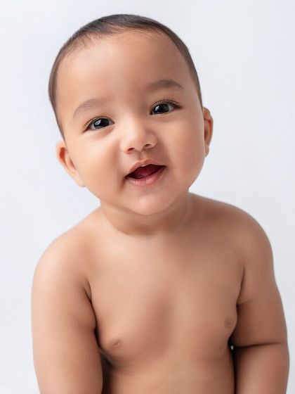 A simple, clean portrait of a happy baby boy against a white background.