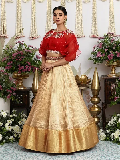 The full view of the beige gold lehenga with the red cape blouse, a perfect fusion of modern and traditional elements.