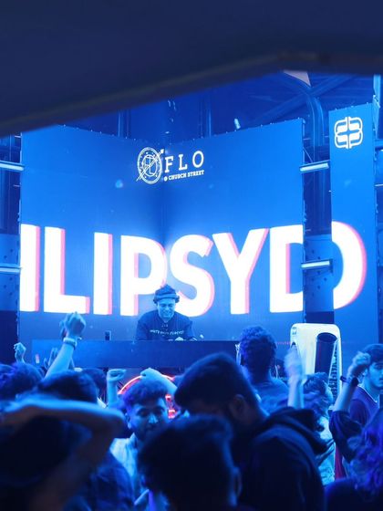 A wide shot of the crowd at Flo, with my name lit up on the big screen. The energy was electric.