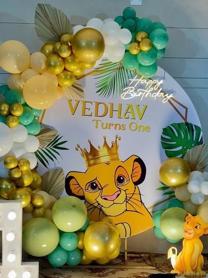 A detailed shot of the Simba-themed first birthday, focusing on the adorable crowned Simba and the elegant balloon work.