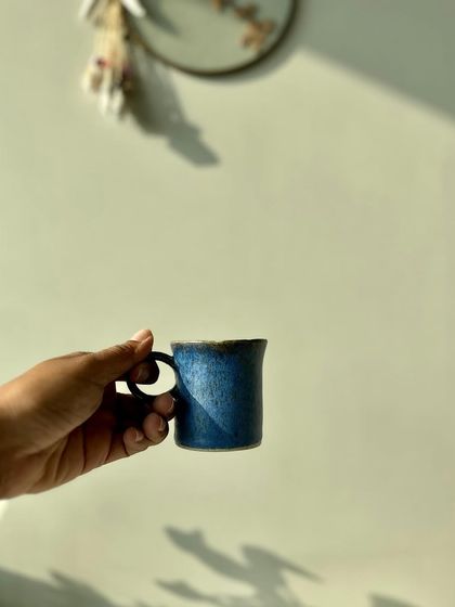 Holding one of our cobalt blue espresso cups. The size and shape are designed to be simple, modest, and perfect for everyday use.
