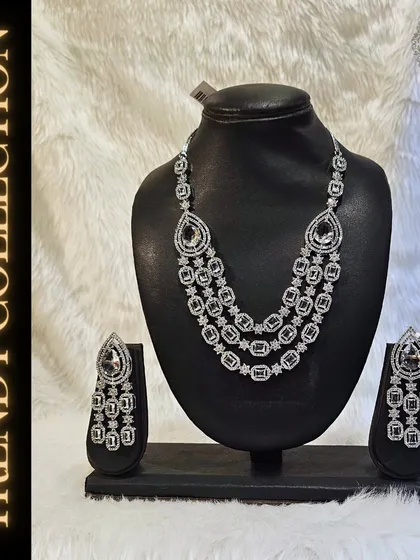 This trendy American Diamond set with cascading earrings and a multi-layered necklace is perfect for a grand reception. Rent, wear, and return for a hassle-free glam look.