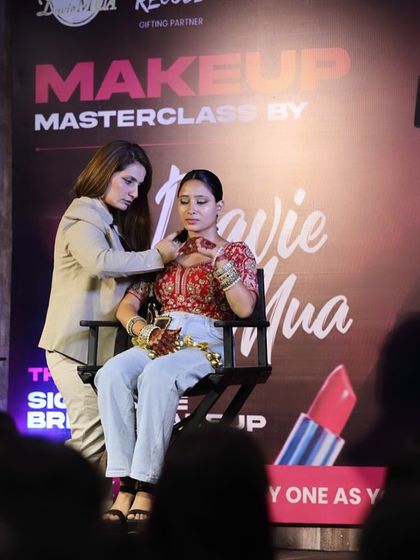 Adjusting the jewelry on the model. A complete look is about makeup, hair, and styling, and I guide my students on all aspects.