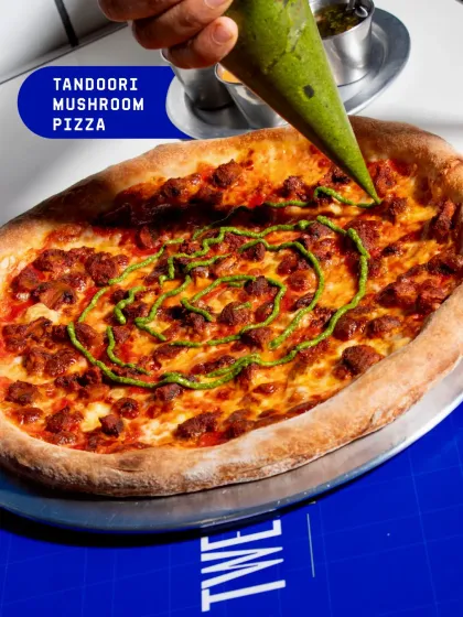 Our Tandoori Mushroom Pizza is a fusion of flavours, with smoky tandoori mushrooms on a cheesy base, finished with a swirl of mint chutney.