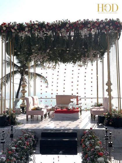A closer look at the seaside mandap, with its backdrop of hanging flower strings against the vast ocean, creating a simple yet breathtaking view.