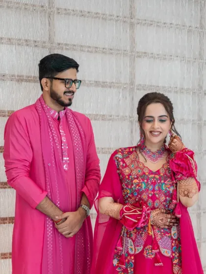 A sweet moment between the bride and groom during their haldi function, dressed in vibrant pink.