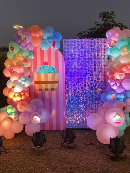 A full view of the cupcake-themed photo booth, complete with wire-frame pedestals and birdcage props.