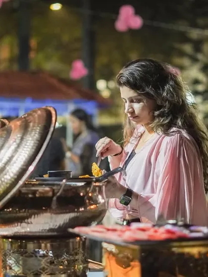 A guest helps herself to our buffet at an evening party. We use elegant copper chafing dishes to keep the food warm and inviting, even for smaller, more intimate gatherings.