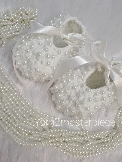 My white pearl booties styled with a string of pearls to emphasize their elegance. The satin ribbon adds a soft, classic finishing touch.