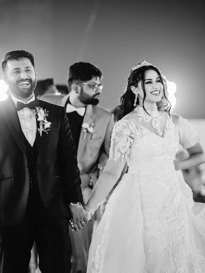 A joyful black and white shot of the couple making their entrance at the reception. This image captures their energy and happiness as they greet their guests.