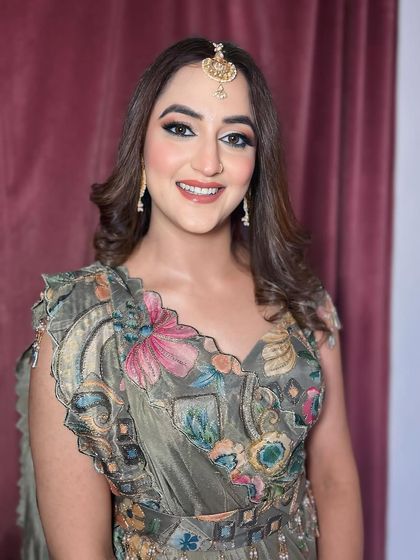 A beautiful guest in a floral outfit. The makeup is soft and pretty, with a focus on rosy cheeks and defined eyes.