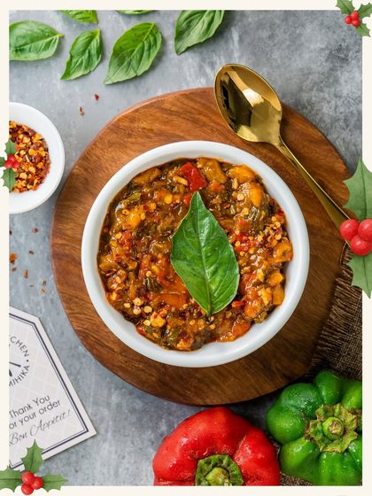 A vibrant red dip garnished with a green basil leaf, perfectly capturing the Christmas spirit.