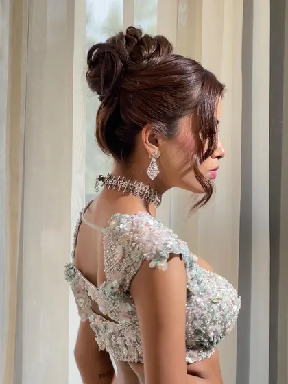 A profile view of the messy high bun. The loose pieces and soft texture give it an effortless feel, while still being very secure.