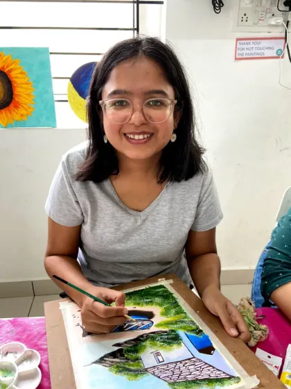 A happy student in our acrylics class, working on a beautiful landscape painting.