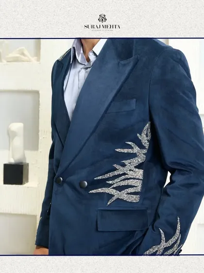 A detail shot of the blue velvet suit, focusing on the texture of the fabric and the sparkling silver embroidery. This is a suit that is both seen and felt.