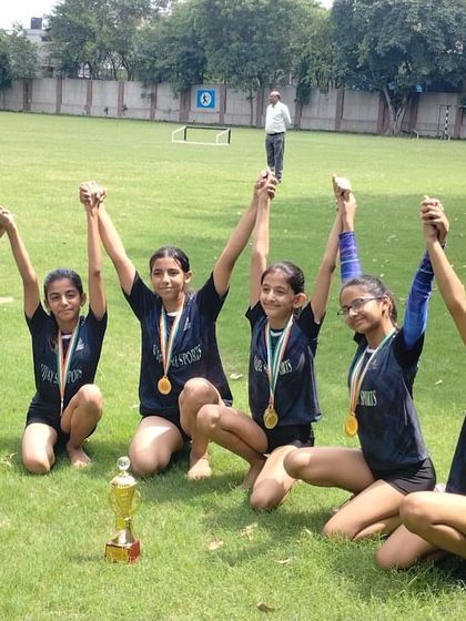Celebrating a big win outdoors. Our Level 4 girls team with their medals and trophy.