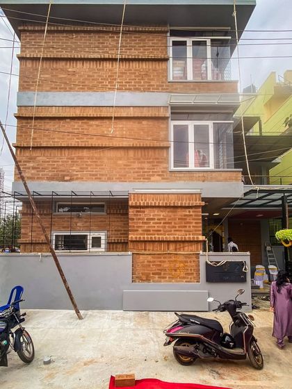 Another perspective of the Tripathy home's facade, highlighting the texture of the mud blocks and the integration of large windows for natural light.