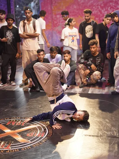 A dancer executes a difficult freeze, showing the athleticism required in top-level breaking. We provide the platform for these moments of peak performance.
