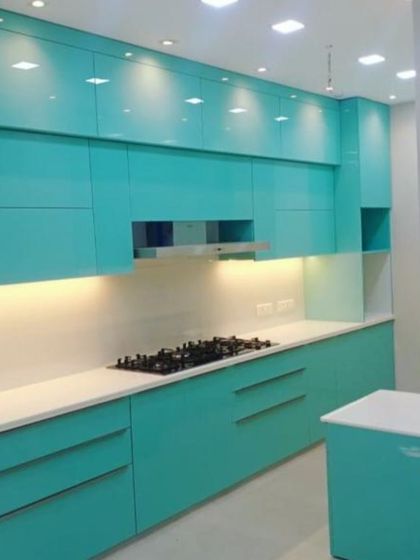 This kitchen in a brilliant turquoise acrylic finish is perfect for those who want a bright and cheerful space. The handle-less design and under-cabinet lighting keep the look modern and clean.