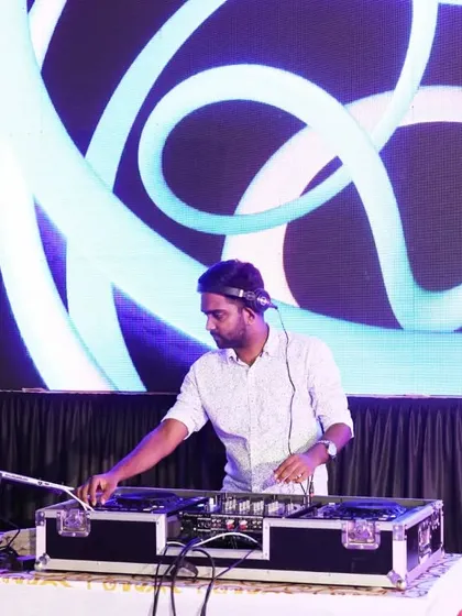 Mixing tracks in front of a cool, swirling blue and white visual display. The combination of audio and visuals is key to a great club night.