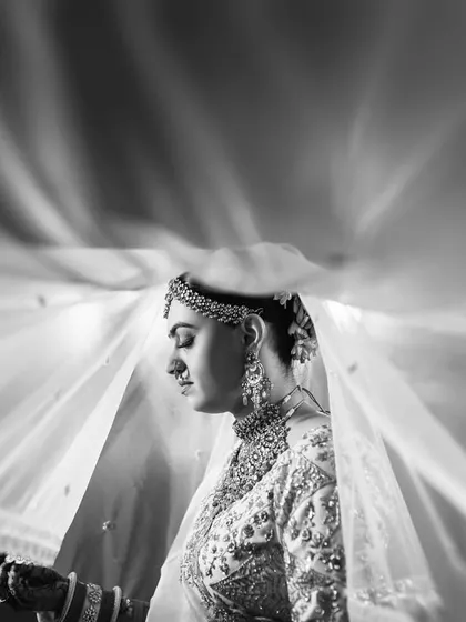 A black and white version of the artistic veil shot, emphasizing the beautiful patterns created by the light and the bride's serene profile.