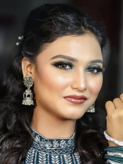 A portrait showing the complete look with a half-up hairstyle and traditional jhumka earrings.