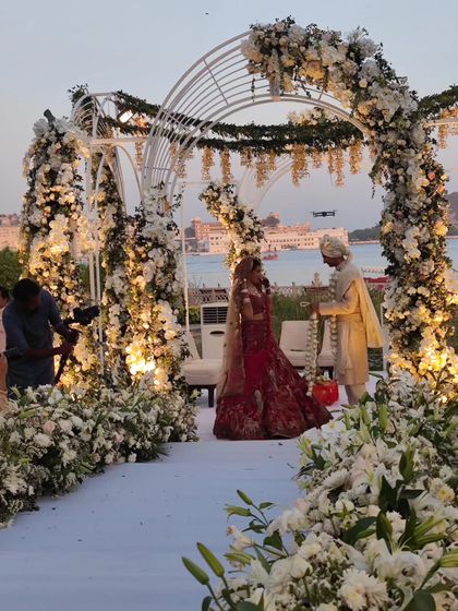 The jaimala ceremony at a stunning lakeside wedding in Udaipur. We are experienced in working alongside other wedding vendors to ensure a seamless event.