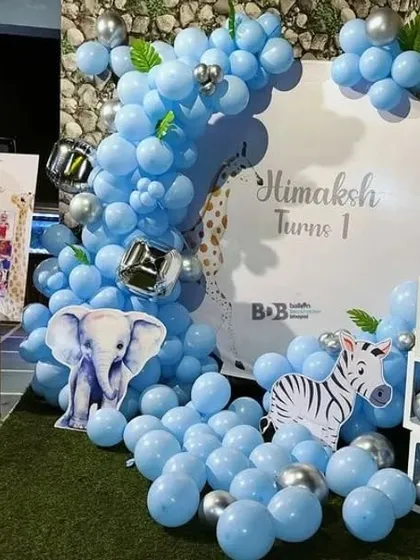 A cute blue-themed first birthday with elephant and zebra cutouts and 'BABY' balloon boxes.