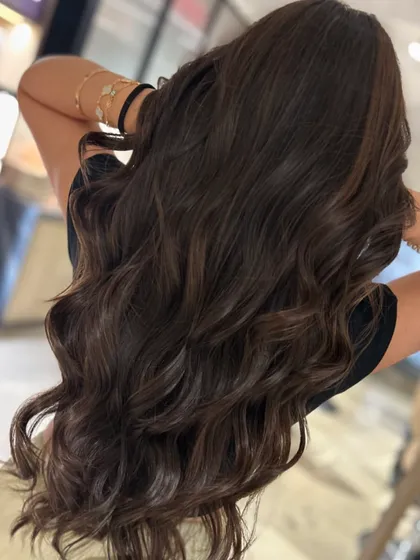 A gorgeous three-tone highlight color for a first-time client, achieved without bleach to maintain hair health. The long hair looks incredibly shiny and vibrant.
