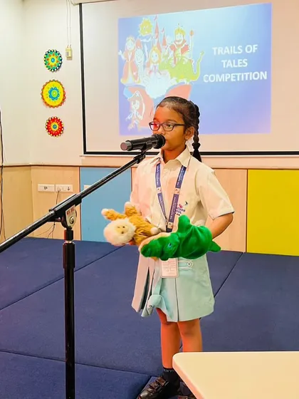 A student uses hand puppets to act out a story, a fantastic way to build language skills and confidence. This method allows children to practice dialogue and character development.