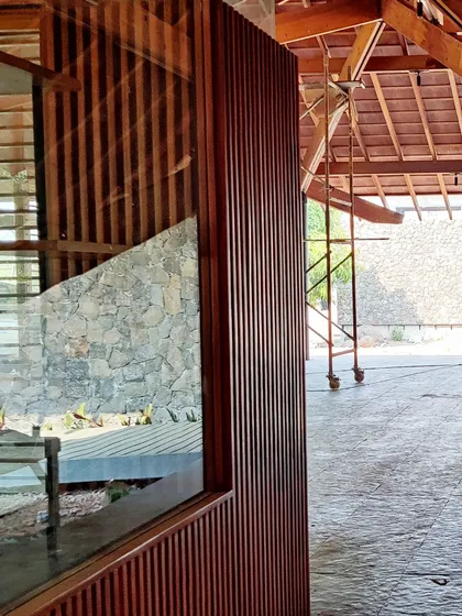 A glimpse of a residence in Alibaug nearing completion. The image shows the beautiful texture of the slatted wood walls against the unfinished interior, a moment of transition.