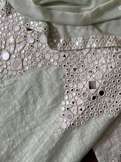 A close-up of the palazzo's hem, where intricate mirrorwork provides a striking contrast to the delicate Chikankari on the kurta.