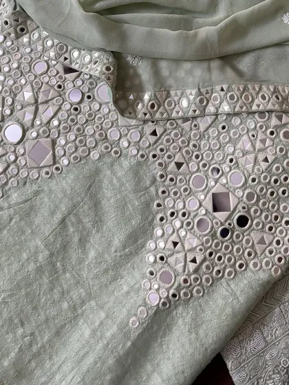 A close-up of the palazzo's hem, where intricate mirrorwork provides a striking contrast to the delicate Chikankari on the kurta.