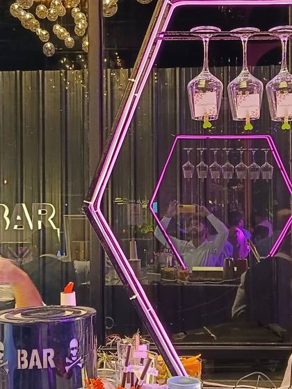 A unique bar design featuring a hexagonal neon frame for hanging glasses, adding a geometric and modern flair.