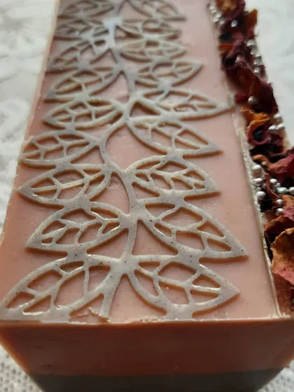A fresh loaf of Charcoal Rose soap, ready to be cut. You can see the detailed stencil work, the layered colors, and the line of dried rose petals I add to every batch.
