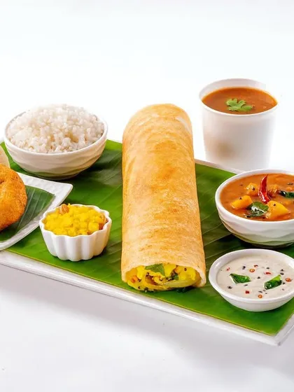 A complete South Indian platter for Vaango. This clean, high-key shot on a banana leaf presents a Dosa, Idli, and Vada together, showcasing a full meal option in a bright and appetizing way.