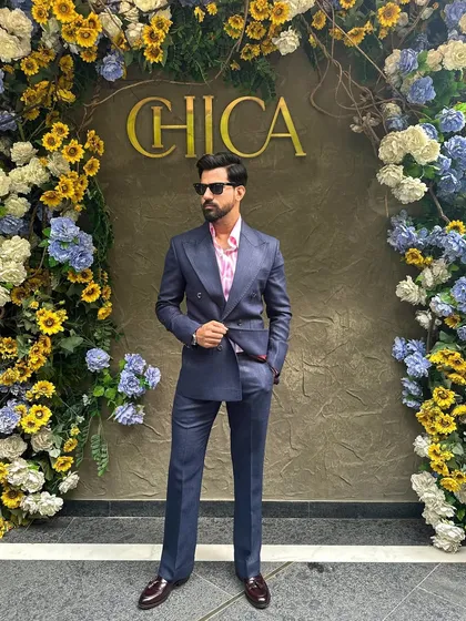 A navy blue double-breasted suit offers a modern alternative to black. Here it is styled with a pink shirt for a pop of color, perfect for a stylish brunch or day event.