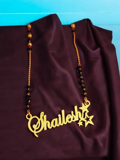 This single-name mangalsutra-style pendant is a great personal accessory. The name is written in a flowing script and is accented with two small stars for a touch of sparkle.