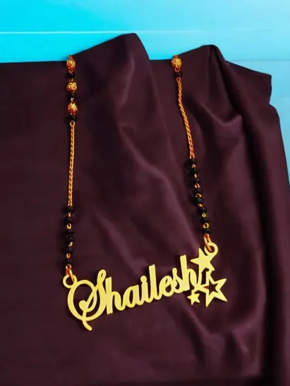 This single-name mangalsutra-style pendant is a great personal accessory. The name is written in a flowing script and is accented with two small stars for a touch of sparkle.