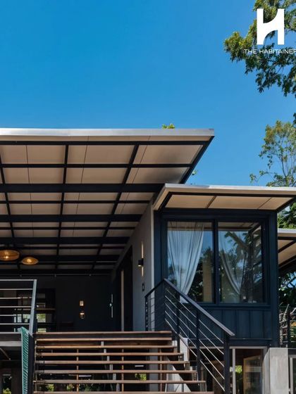 The exterior staircase and shared deck connect the different units of the Coorg project, creating a sense of community while maintaining privacy. The design is both functional and aesthetically pleasing.