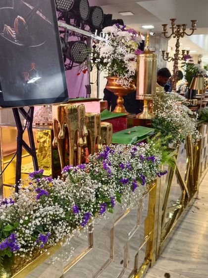 We also decorate functional areas with style. This buffet counter is lined with an elegant arrangement of baby's breath and purple flowers, enhancing the overall event aesthetic.
