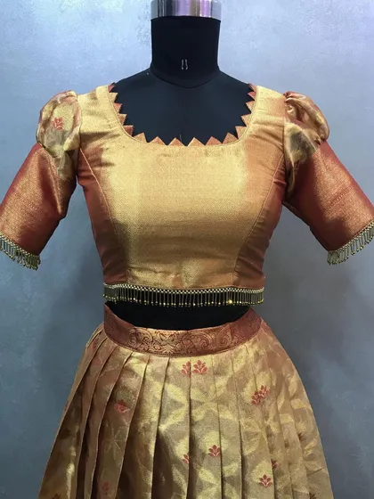 A close-up look at the blouse craftsmanship. This design features a unique zigzag neckline and delicate tassels on the puff sleeves for a special touch.