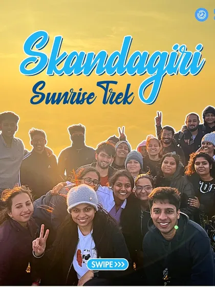 A happy group celebrates after completing the Skandagiri Sunrise Trek. We offer quick, rewarding one-day treks like this, perfect for watching a magical sunrise over a sea of clouds.